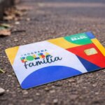 Cartão do Bolsa Família caído no chão da rua representando perda do cartão do benefício