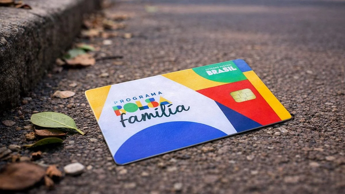 Cartão do Bolsa Família caído no chão da rua representando perda do cartão do benefício